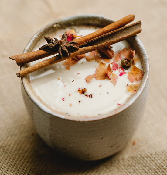 Cup of coffee with cream and cinnamon sticks